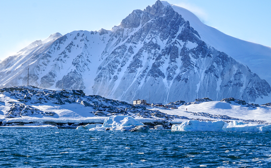 Huge White Mountain towers over an old British Base on an island in Antarctica