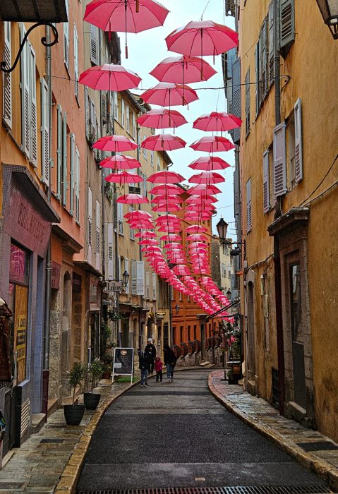 Red Umbrellas over a narrow street in Grasse, France
